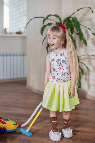 Gelukkig vrij klein blond meisje reinigen van huis - Foto, afbeelding