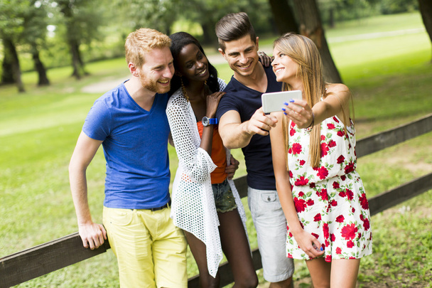 Giovani amici multirazziali scattare selfie nel parco
 - Foto, immagini