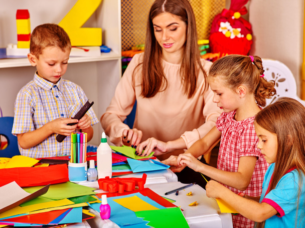 Enfants tenant du papier coloré sur la table à la maternelle
 . - Photo, image
