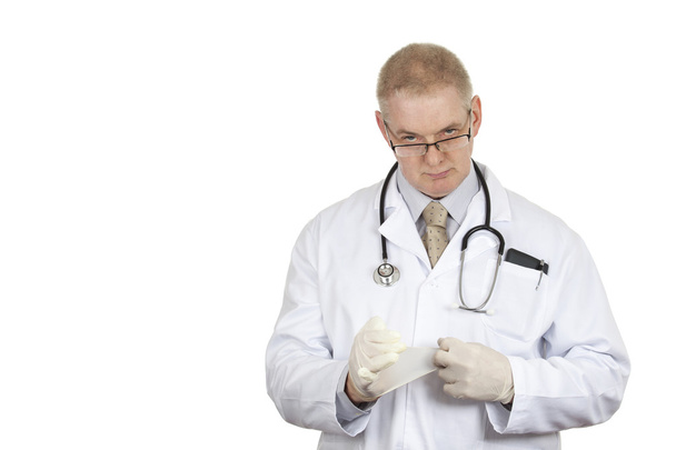 Médecin portant des lunettes et stéthoscope mettant du latex sur des gants
 - Photo, image
