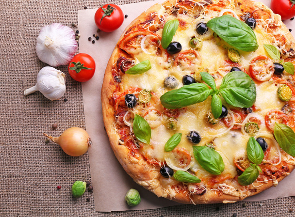 Delicious fresh pizza on sackcloth, top view - Foto, immagini
