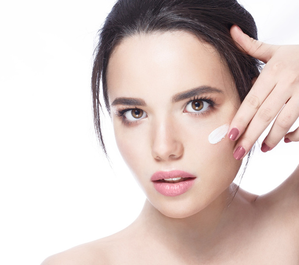 schönes Modell Anwendung kosmetischer Creme Behandlung auf ihr Gesicht auf weißer, frischer Haut, Lächeln - Foto, Bild