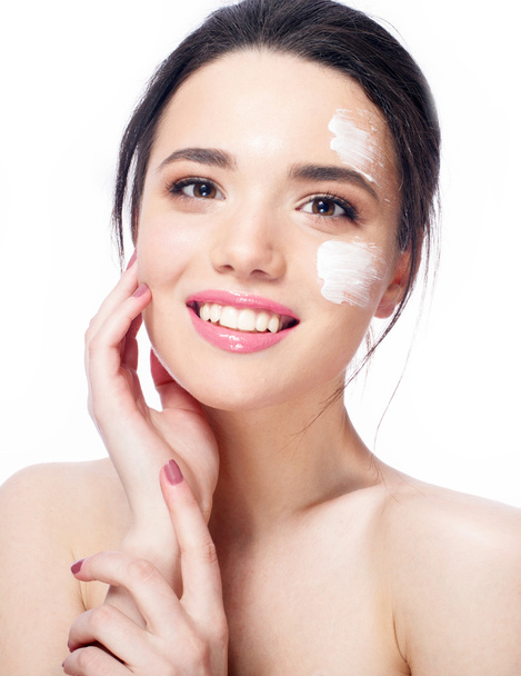 beautiful model applying cosmetic cream treatment on her face on white fresh skin, smile - 写真・画像