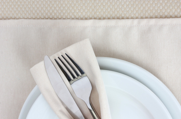Table setting with fork, knife, plates, and napkin - Photo, image