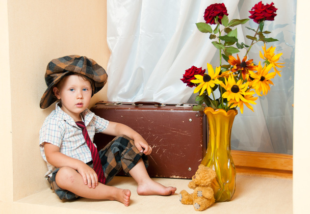 χαριτωμένο μικρό αγόρι με το λουλούδι που κάθεται σε μια παλαιά βαλίτσα. Αυτός εγώ - Φωτογραφία, εικόνα