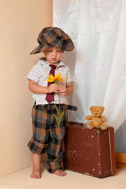 Cute little boy with the flower. He is wearing a hat. - Fotografie, Obrázek