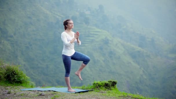 Mujer haciendo yoga asana árbol pose al aire libre
 - Imágenes, Vídeo