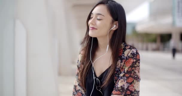 イヤホンで音楽を聴き歩いている女性 - 映像、動画