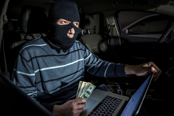 Hacker com um laptop dentro de um carro
 - Foto, Imagem