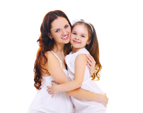 Щаслива усміхнена мати обіймає маленьку доньку на білому ба
 - Фото, зображення