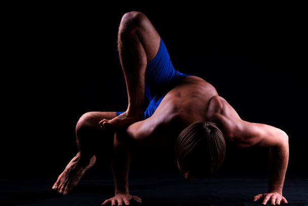 Jonge man houdt zich bezig met yoga - Foto, afbeelding
