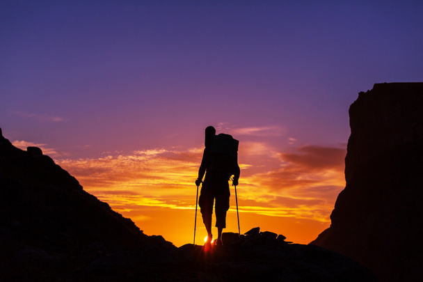 Silhueta de caminhante ao pôr-do-sol
 - Foto, Imagem