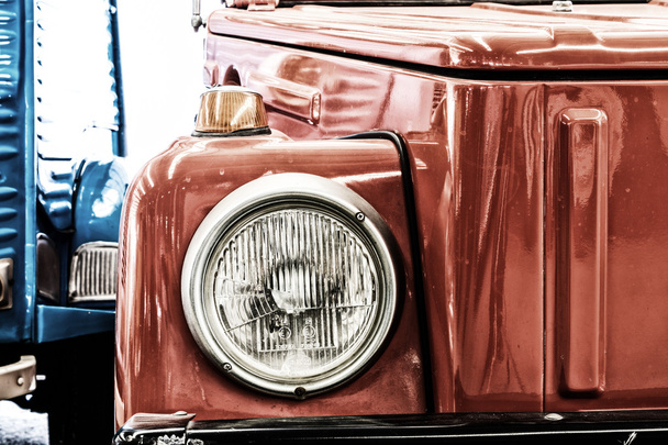 Κοντινό πλάνο της προβολέα φανός σκούρο κόκκινο εκλεκτής ποιότητας κλασικό αυτοκίνητο. (Στυλ vintage αποτέλεσμα) - Φωτογραφία, εικόνα