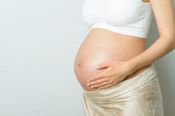 pregnant belly at white background - Foto, Imagen
