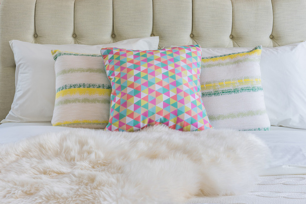 πολύχρωμα μαξιλάρια στο λευκό κρεβάτι στην σύγχρονη κρεβατοκάμαρα  - Φωτογραφία, εικόνα