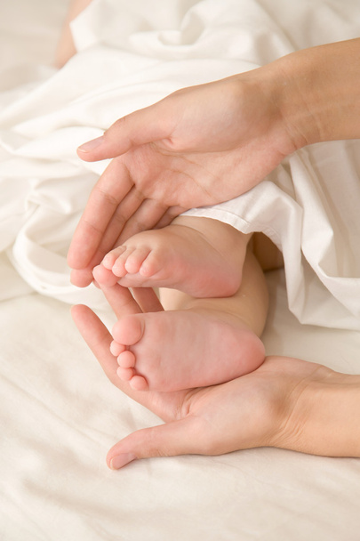 Vauvan jalat äidin käsissä
 - Valokuva, kuva