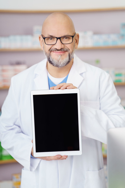 Smiling pharmacist displaying a blank tablet - Fotografie, Obrázek