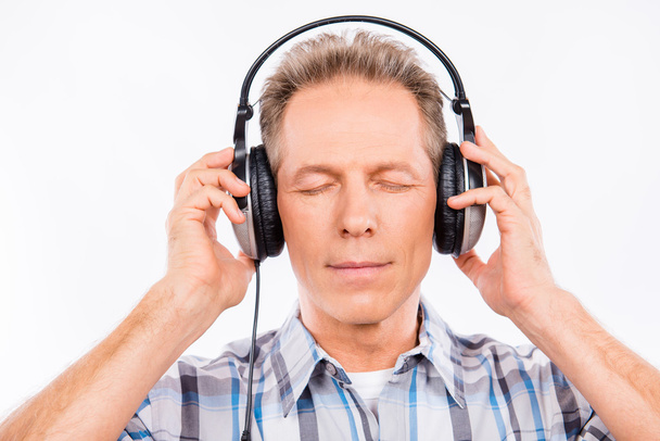 Aged calm hipster with headphones listening to music - Foto, Imagen