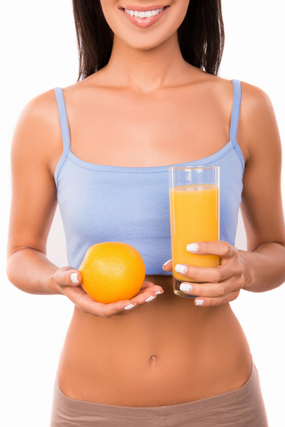 cheerful sexy woman with orange and glass of orange juice - Foto, afbeelding