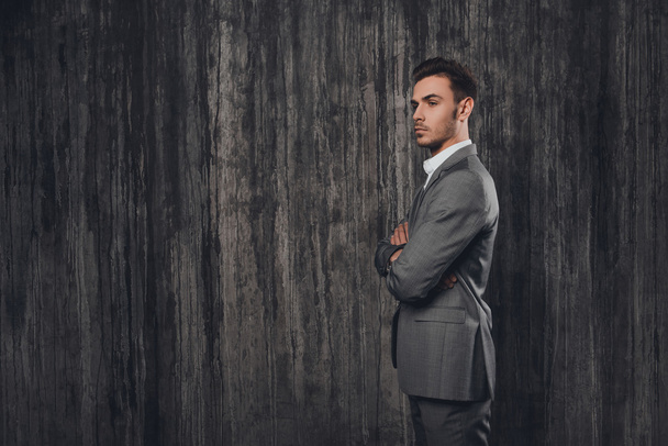 Side view portrait of handsome businessman posing with crossed h - Foto, Bild