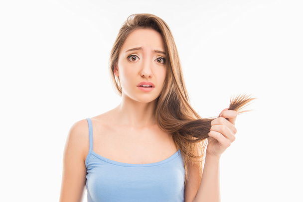 Sad unhappy young girl showing her damaged split ends - Foto, Imagen