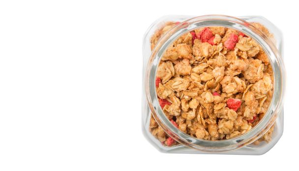 Breakfast cereal with dried raspberry pieces in glass jar over white background - Photo, Image