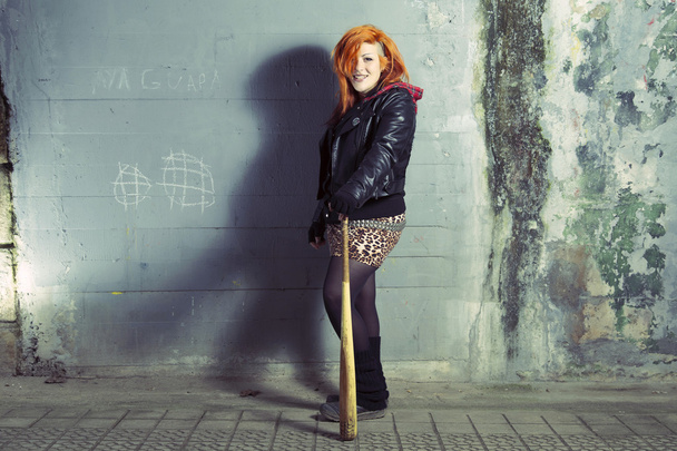 Mujer punk sonriente posando con un bate de béisbol
. - Foto, Imagen