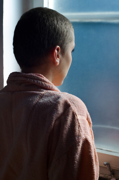 Young cancer patient standing in front of hospital window - Photo, Image