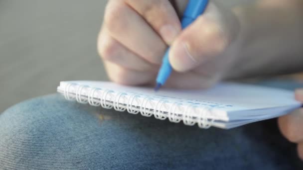 Ember kéz írni valami papír notebook kék jelölőt. Szúnyog - Felvétel, videó