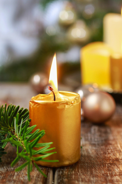 Beautiful golden candle and fir branch. - Foto, afbeelding