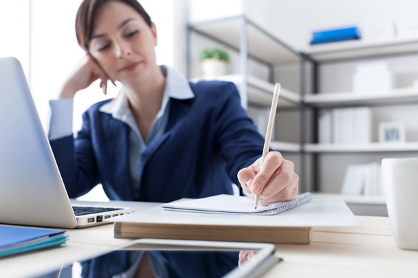 Businesswoman writing notes on a notebook - Foto, imagen