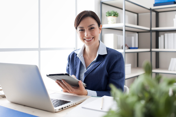 Smiling office worker using a tablet - Zdjęcie, obraz