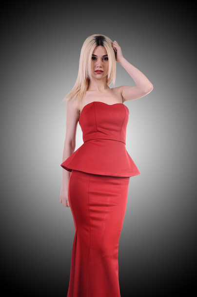 Красива модель моди залишатися в елегантній позі, сексуальна модель в червоній сукні позує еластично, мила модель залишатися і дивитися вниз прекрасна
 - Фото, зображення