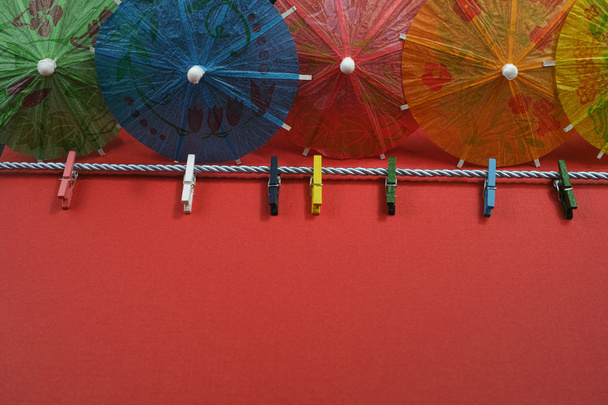 Colorful washline with clothespins and paper umbrellas, copy spa - 写真・画像