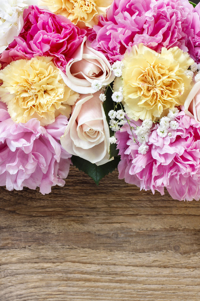 Stunning pink peonies, yellow carnations and roses on rustic woo - Fotó, kép