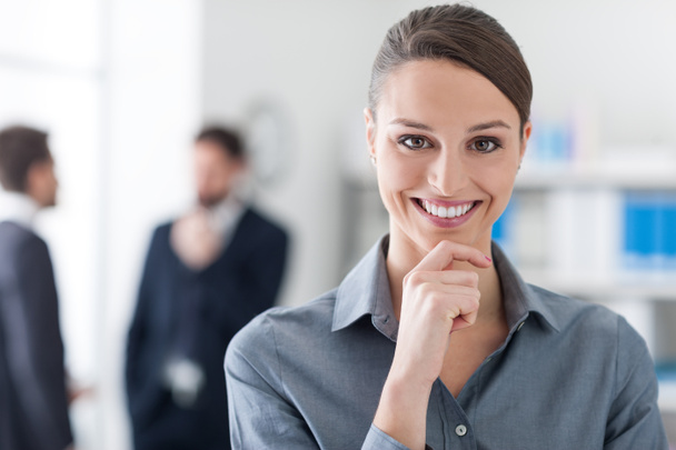 Confident businesswoman with hand on chin - Foto, imagen
