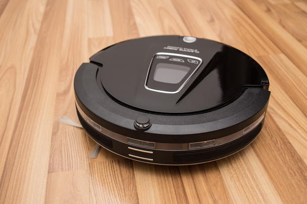 Robotic vacuum cleaner on wood parquet floor - Zdjęcie, obraz