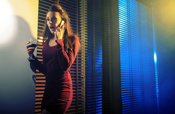 Mujer joven curiosa hablando en el teléfono celular
 - Foto, imagen