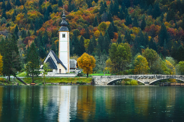 Hermosa vista de colorida escena otoñal de la famosa Iglesia de San Juan Bautista, Lago Bohinj, Ribicev Laz, pueblo turístico en Eslovenia
 - Foto, imagen