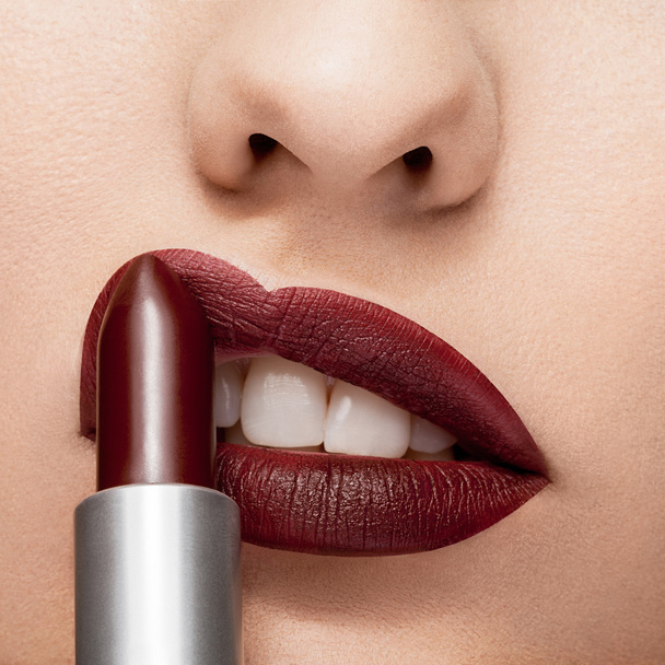 Red lipstick getting applyed on lips - 写真・画像