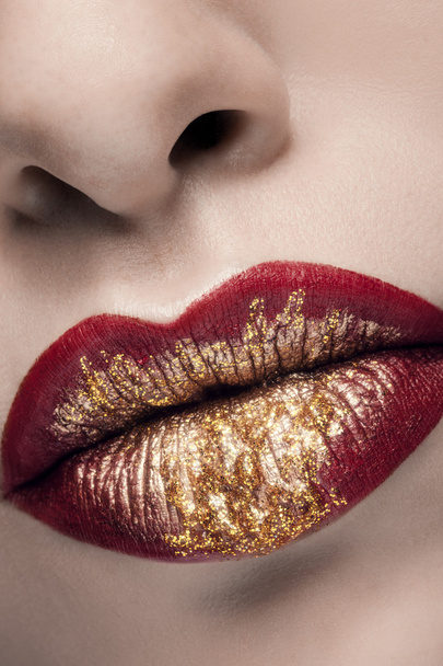 Gouden en rode lippenstift in mode make-up - Foto, afbeelding