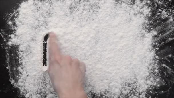 Uma mão escrevendo na farinha branca
 - Filmagem, Vídeo