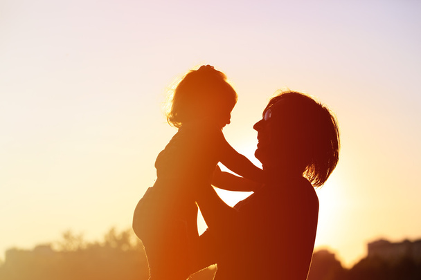 силуети батька і маленької дочки на заході сонця
 - Фото, зображення