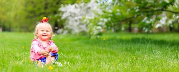 schattig gelukkig klein meisje geniet van de lente natuur - Foto, afbeelding