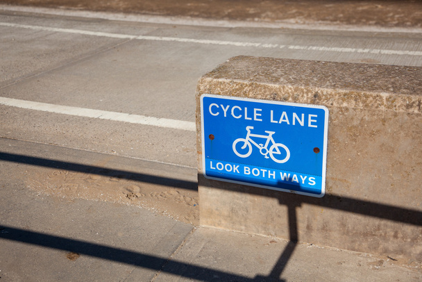 Blue cycle path lane sign by beach - Photo, Image
