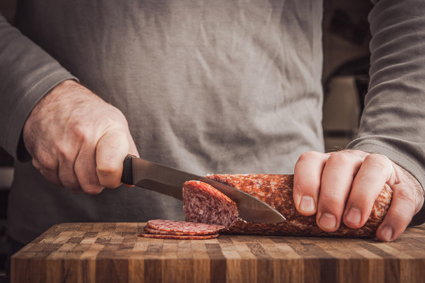 Man cutting sausage - Fotó, kép