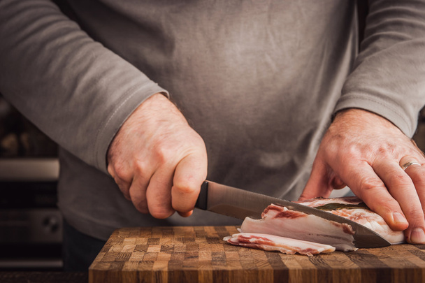 Man cutting lard in the kitchen - Zdjęcie, obraz