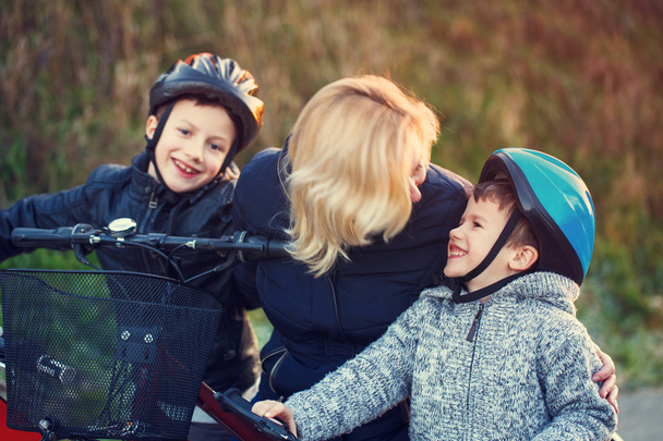 Mãe ensinando crianças de ciclismo ao ar livre no outono
 - Foto, Imagem