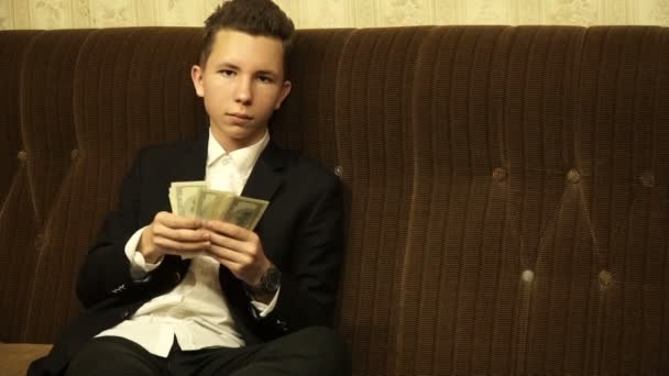 adolescente sentado en el sofá cuenta dinero
 - Metraje, vídeo