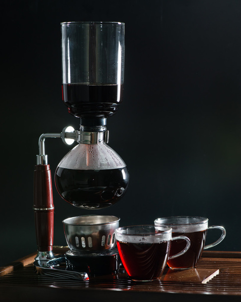 Puer tea in the siphon, shallow DOF, on black background - Foto, afbeelding